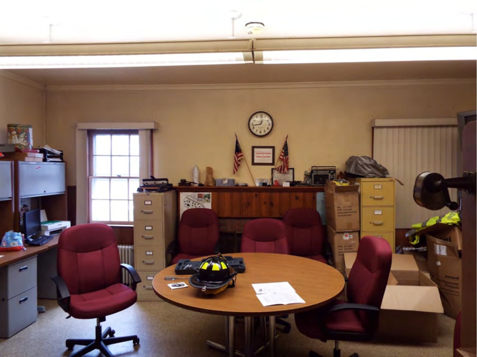 First-floor break room with knotty pine wainscoting and ornamental fireplace.